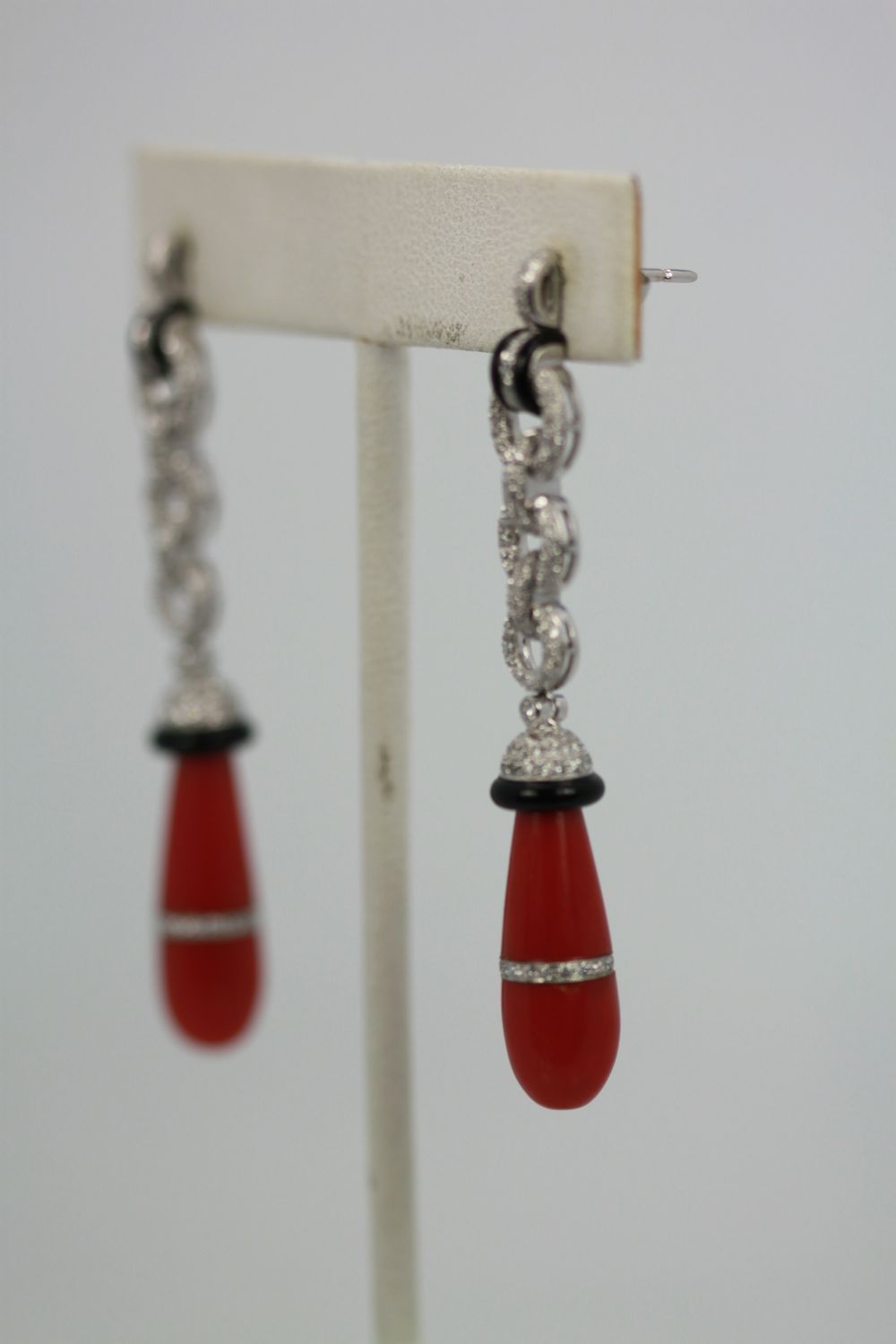 Eli Frei 18K White Gold, Coral & Onyx Drop Earrings on stand soft focus
